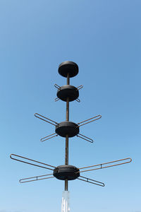 Low angle view of communications tower against clear blue sky