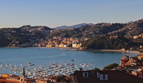 High angle view of city by sea and buildings against sky