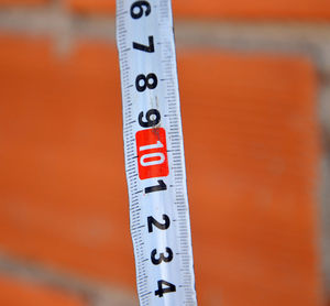 High angle close up of measuring tape against brick wall