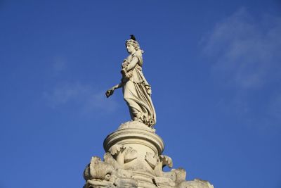 Low angle view of statue against blue sky