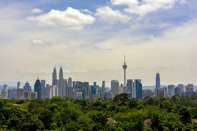 View of cityscape against cloudy sky