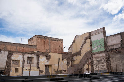 Low angle view of buildings against cloudy sky