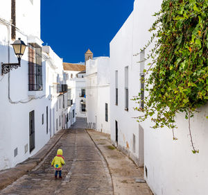 Rear view of baby walking on narrow street at vejer de la frontera