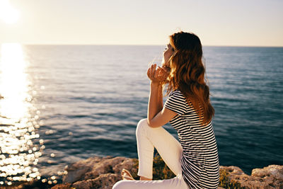 Woman looking at sea against sky