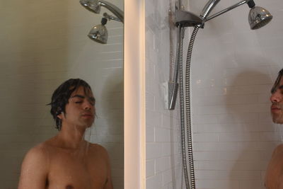 Young man looking on the shower