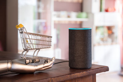 Shopping cart and smart speaker with voice recognition. ai represent as a robot hand.
