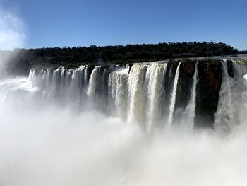 Scenic view of waterfall against sky