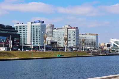 River by buildings against sky in city