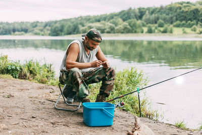 A young fisherman catches fish on a lake or river, prepares tackle and bait. hobbies, weekends