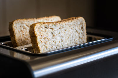 Close-up of bread slices in toaster on table