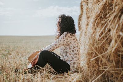 Rear view of woman by hay bale