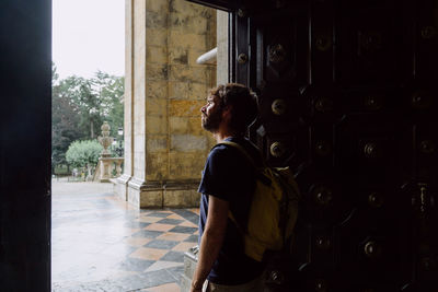 Rear view of woman standing against wall