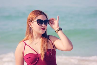 Young woman with sunglasses against sky