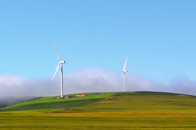 Windmill on field against sky