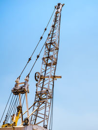 Low angle view of cranes against clear sky