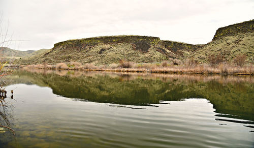 Scenic view of lake by trees against sky