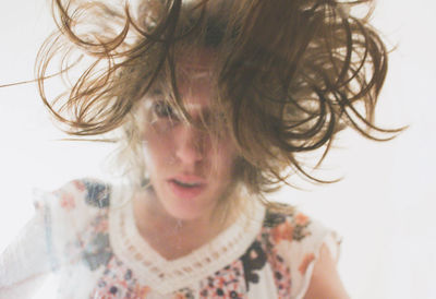 Close-up of young woman tossing hair