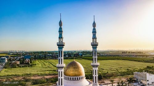 Communications tower in city against sky