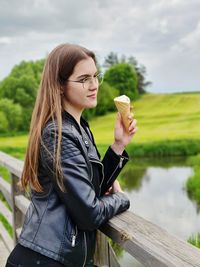 Young woman with ice cream cone at lake