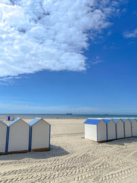 Lifeguard hut on beach against blue sky