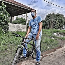 Full length of man standing on bicycle against plants