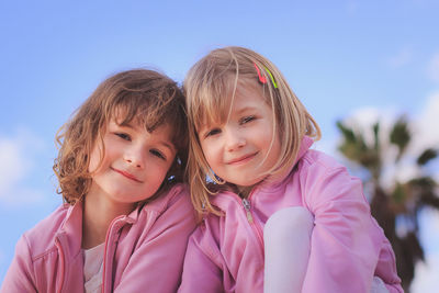 Portrait of smiling friends against sky