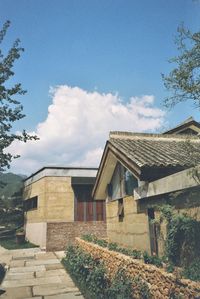 Houses by trees against sky