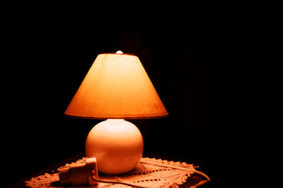 Close-up of illuminated lamp in darkroom