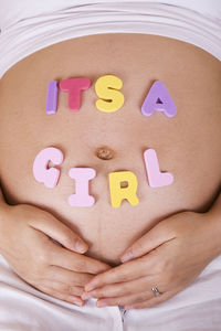 Close-up of its a girl text on pregnant woman abdomen