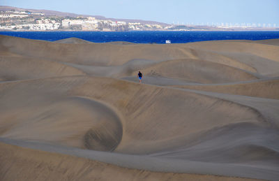 Man walking on sand dune