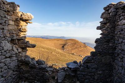 Scenic view of rocky mountains against sky from ruina of and ancient wall