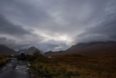 Road leading towards mountains against sky