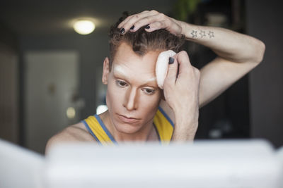 Young man applying pressed powder