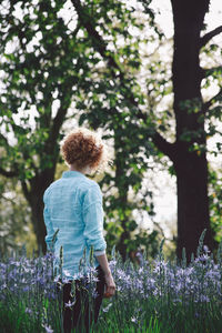 Rear view of young woman standing in lavender field