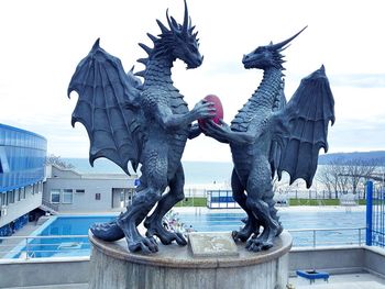 Statue of birds against sky in city