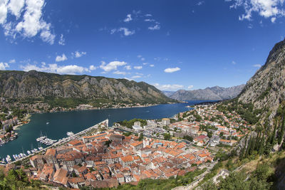 High angle view of townscape by mountains against sky