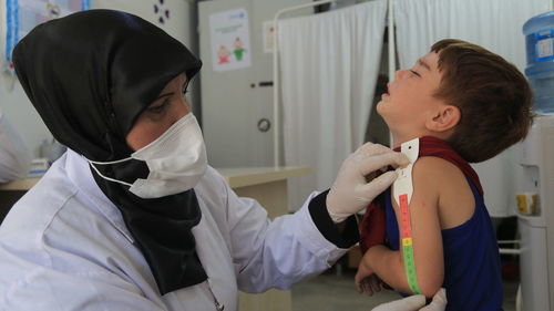 Side view of doctor examining patient at home