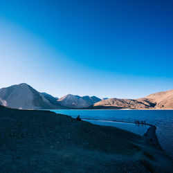 Scenic view of snowcapped mountains against clear blue sky