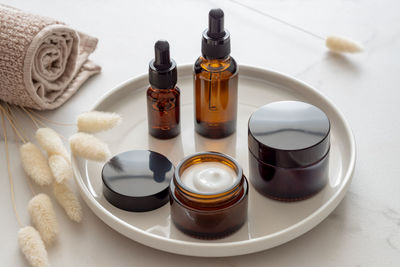 Beauty cosmetic skincare products on marble bathroom table, set of jars, droppers and bottles. 