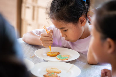 Girl decorating cookies at home