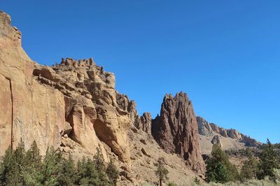 Low angle view of rock formation against clear blue sky