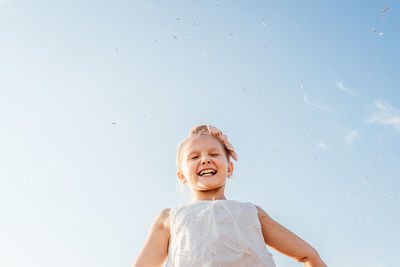 Portrait of smiling girl against sky