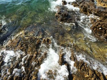 High angle view of surf at rocky shore