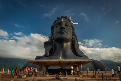 Statue in temple against cloudy sky