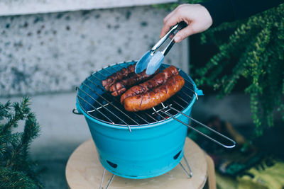 Close-up of person preparing food on barbecue