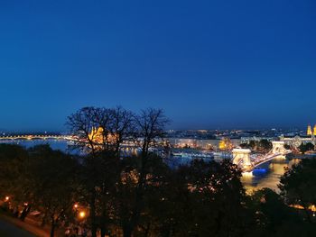 High angle view of illuminated buildings against blue sky