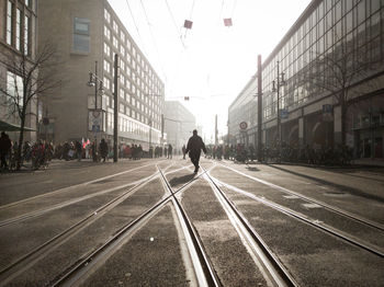 Man on road in city against sky