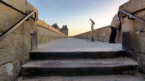 Man standing on bridge against sky