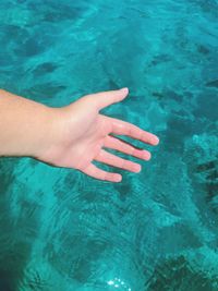 Cropped hand of person in swimming pool