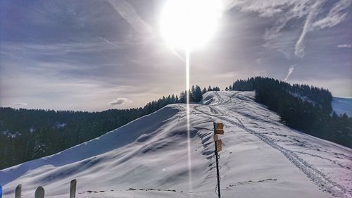 Snow covered landscape against sky